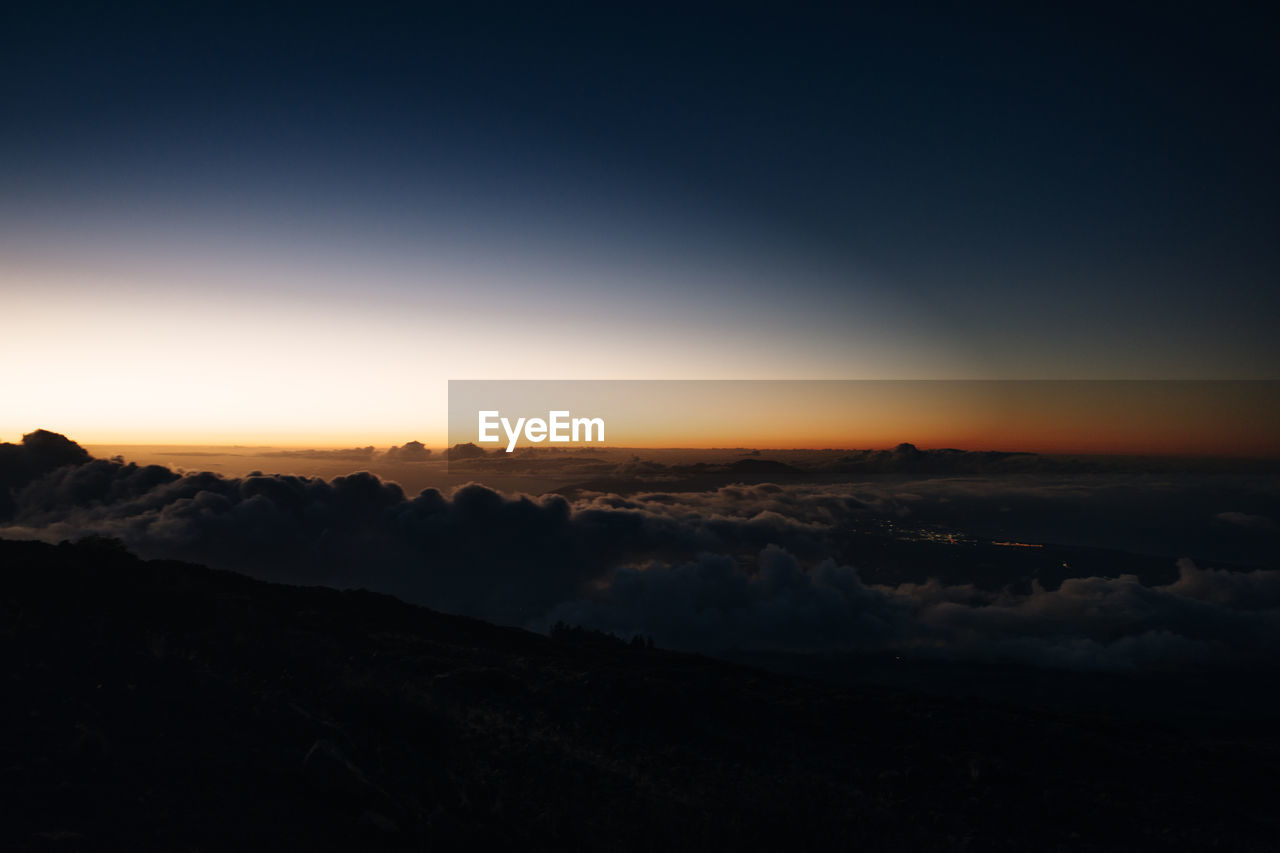 scenic view of mountains against clear sky at sunset
