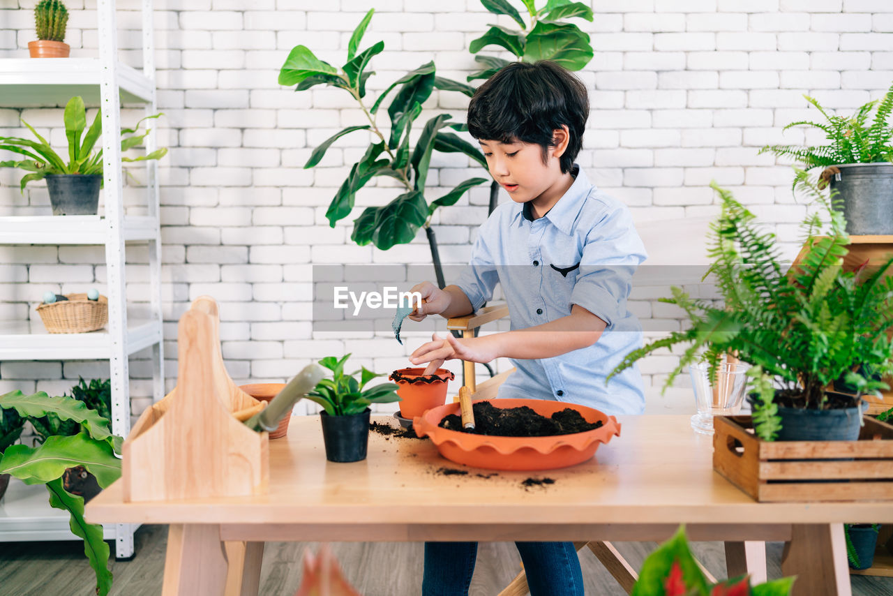 WOMAN HOLDING FOOD IN POTTED PLANTS