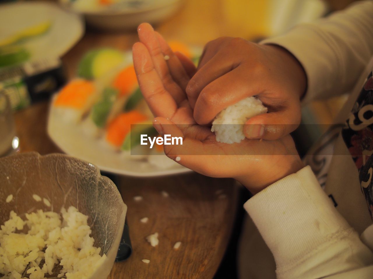Cropped image of hands making sushi at home