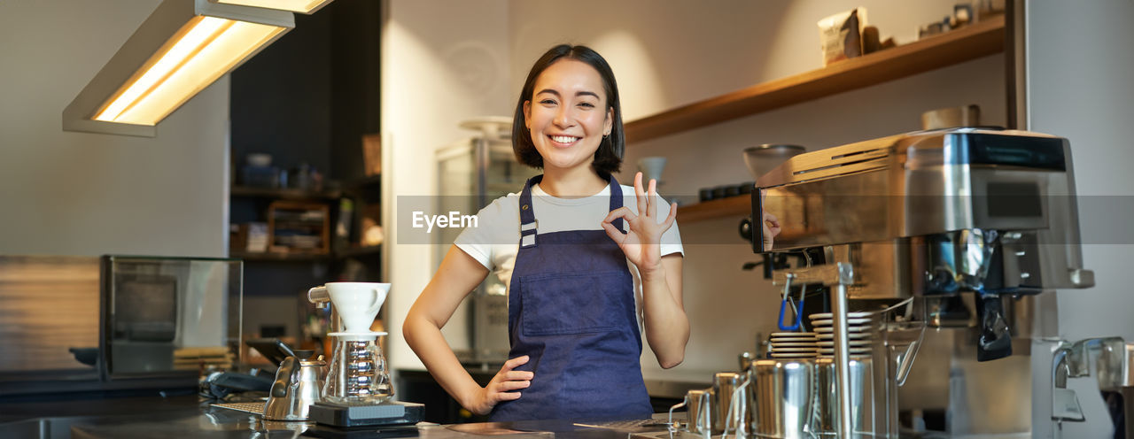 portrait of young woman standing at table