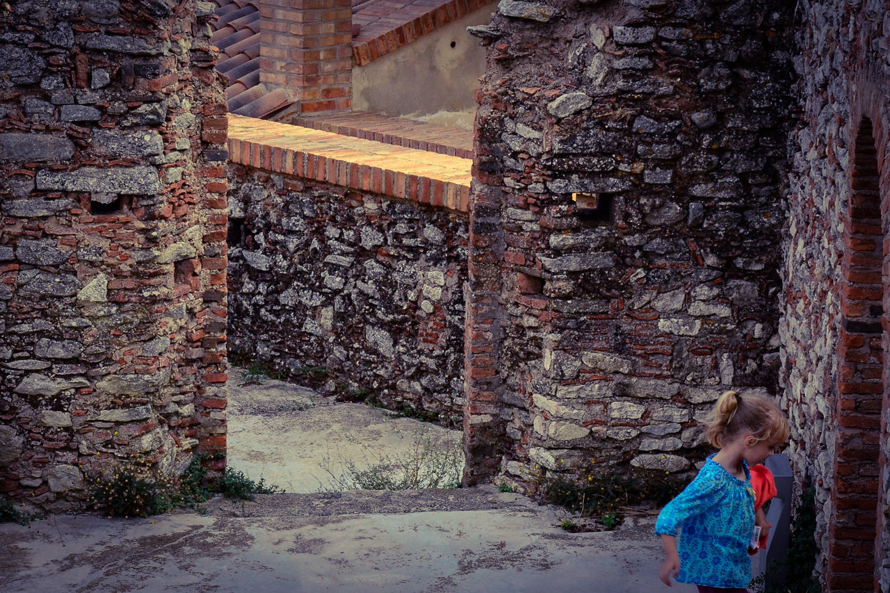 FULL LENGTH OF WOMAN STANDING BY WALL