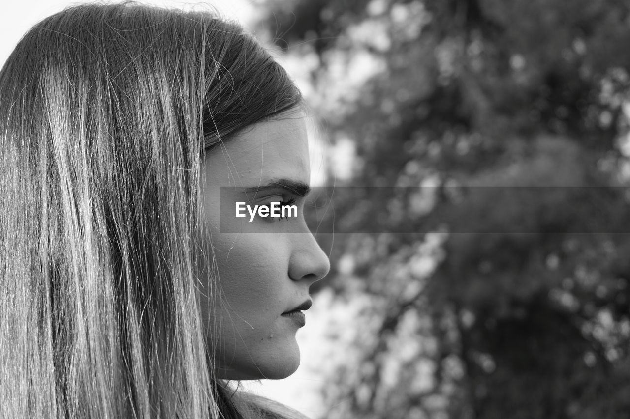 CLOSE-UP PORTRAIT OF YOUNG WOMAN LOOKING AWAY