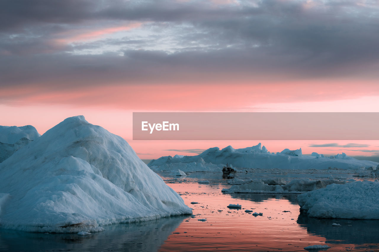 Scenic view of frozen lake against sky during sunset