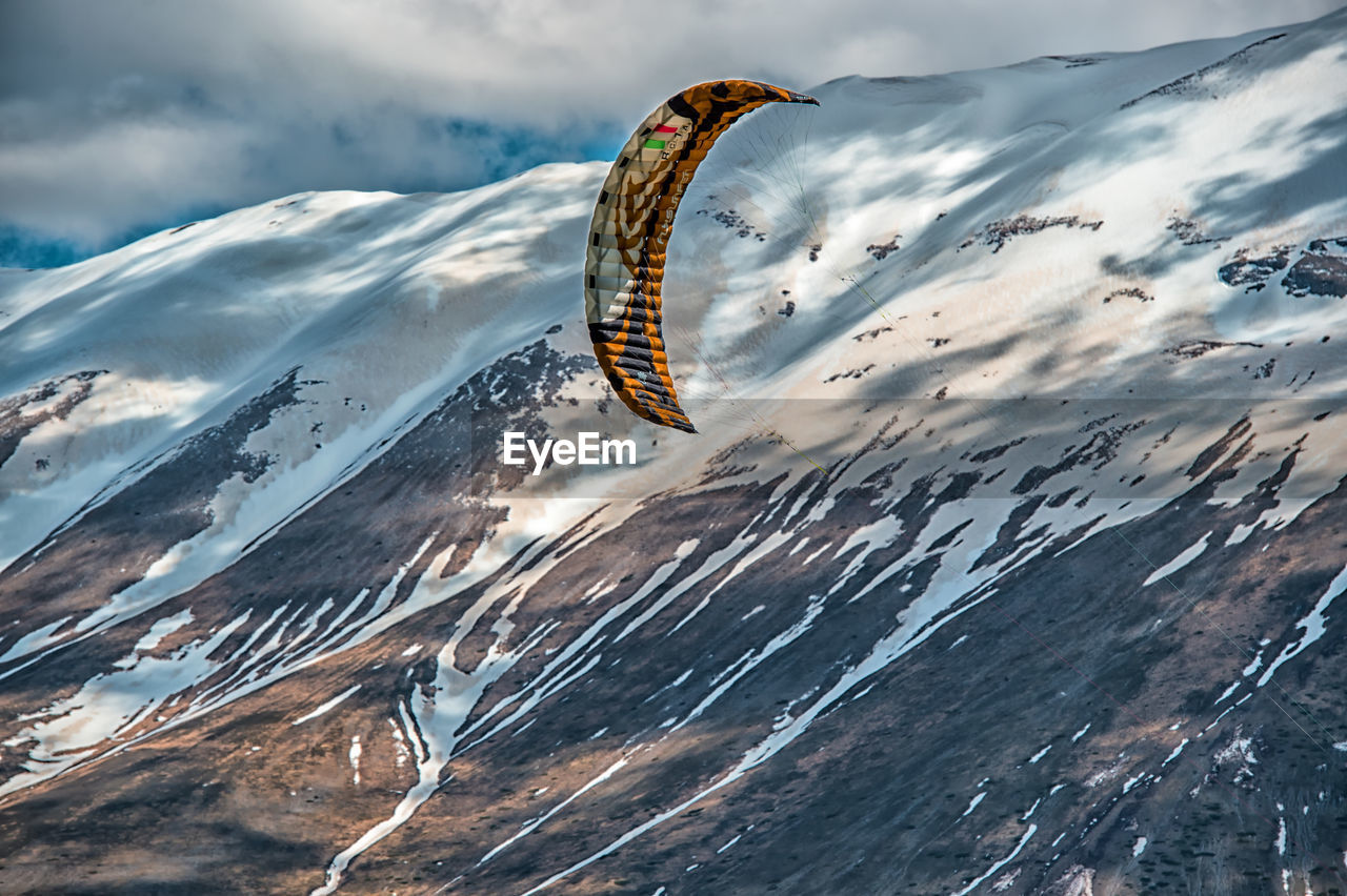 Aerial view of snow covered mountains against sky