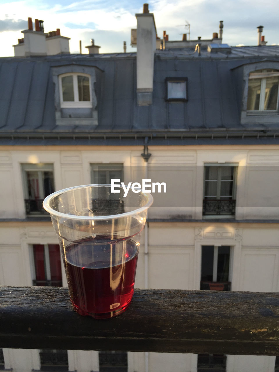 Drink on railing against building