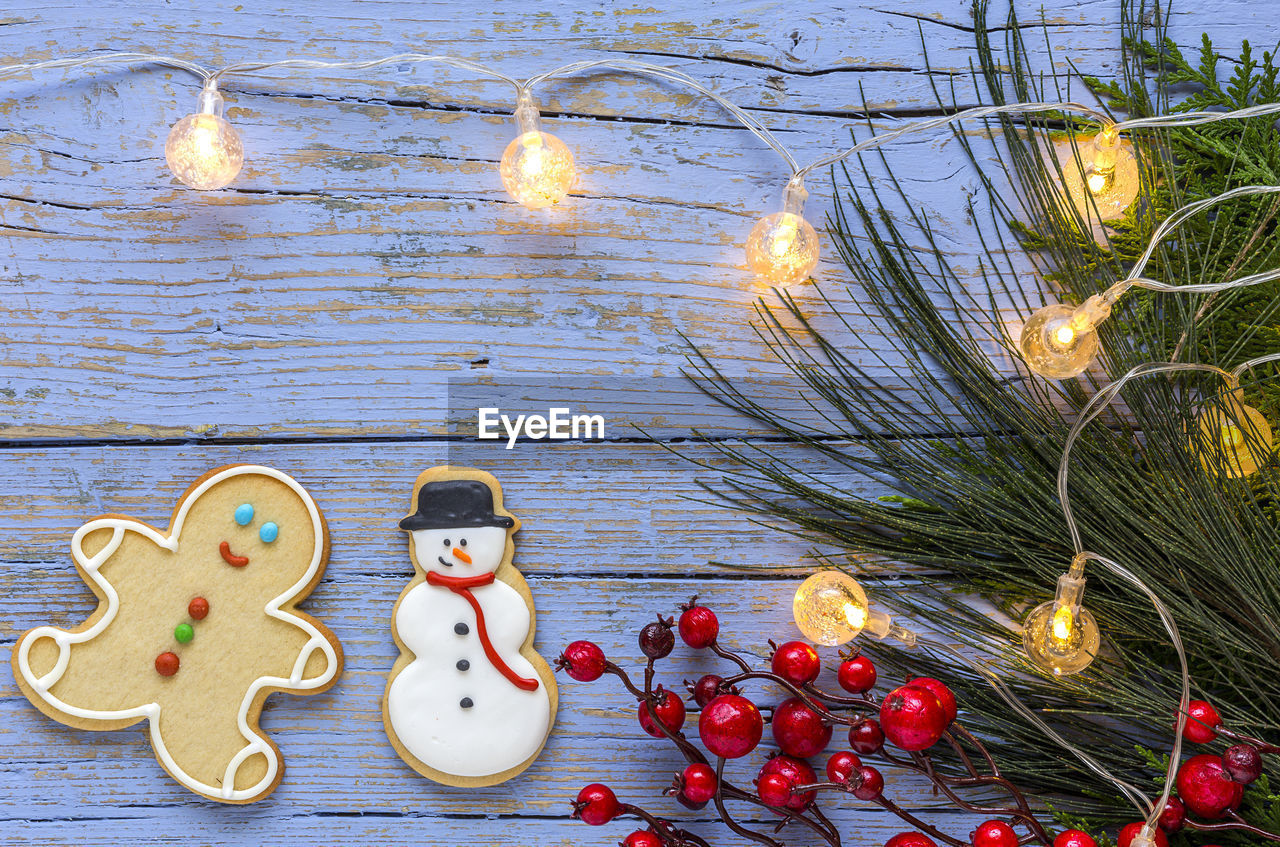 Directly above shot of gingerbread cookies on decorated wooden table