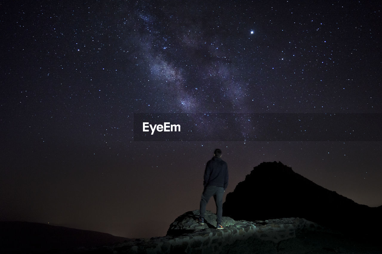 Man standing against sky at night