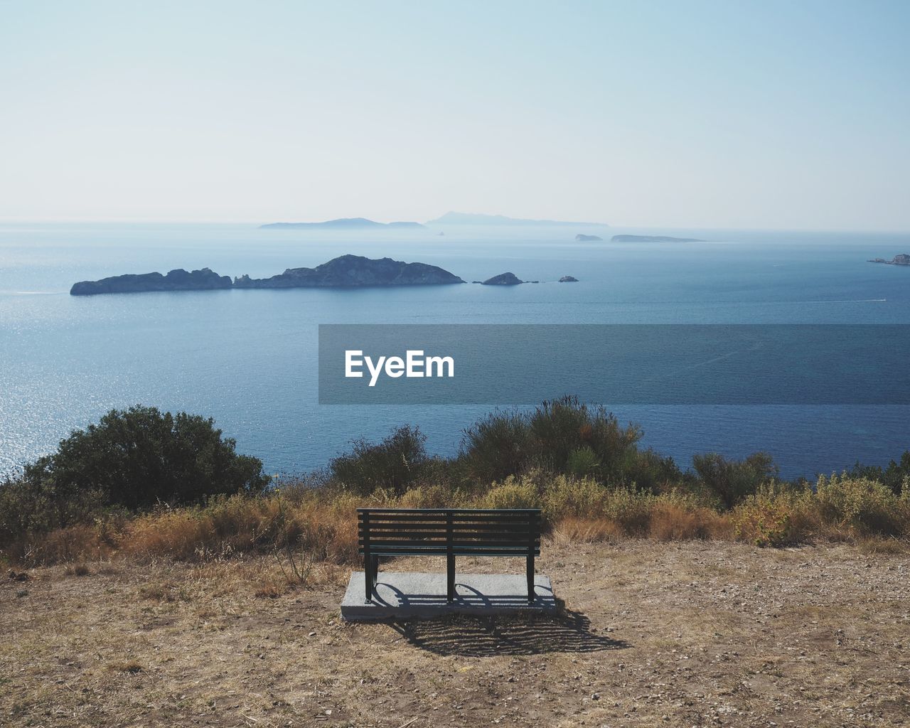 BENCH ON BEACH AGAINST CLEAR SKY