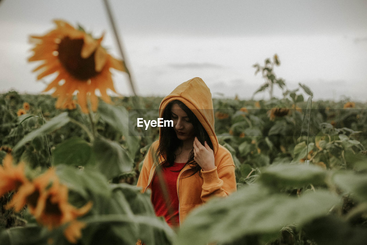 Young woman standing at sunflower farm