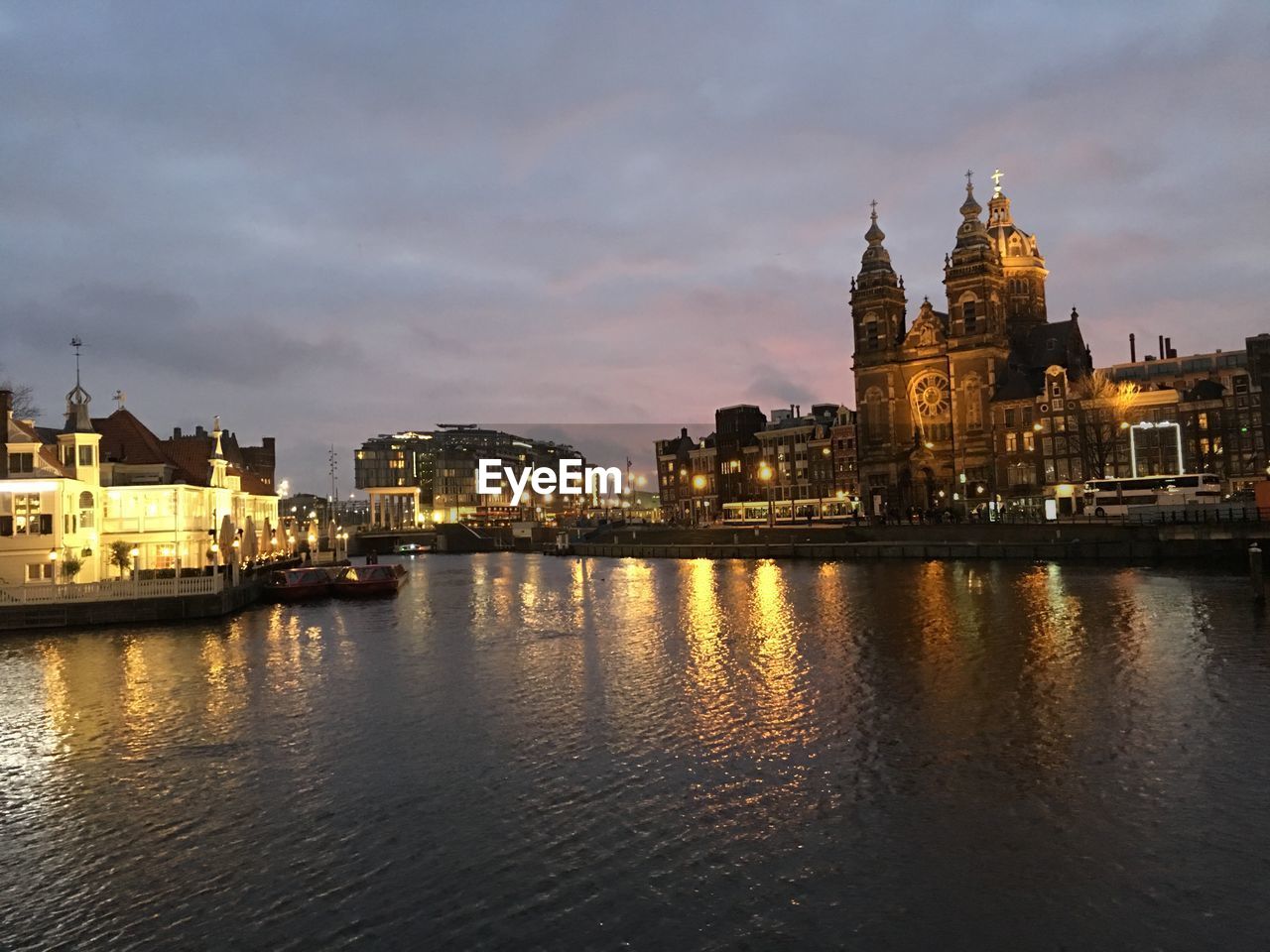 REFLECTION OF ILLUMINATED BUILDINGS IN WATER AT DUSK