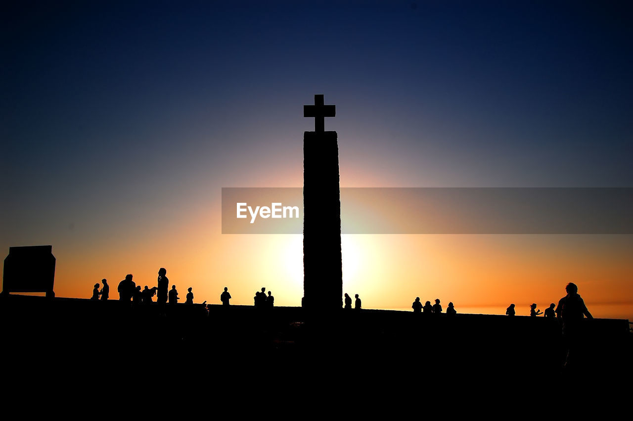 lighthouse, silhouette, architecture, sky, horizon, tower, sunset, dawn, built structure, building exterior, skyline, group of people, nature, evening, travel destinations, large group of people, crowd, building, orange color, travel, outdoors, guidance, history, afterglow, clear sky, backlighting, the past, city, copy space, night