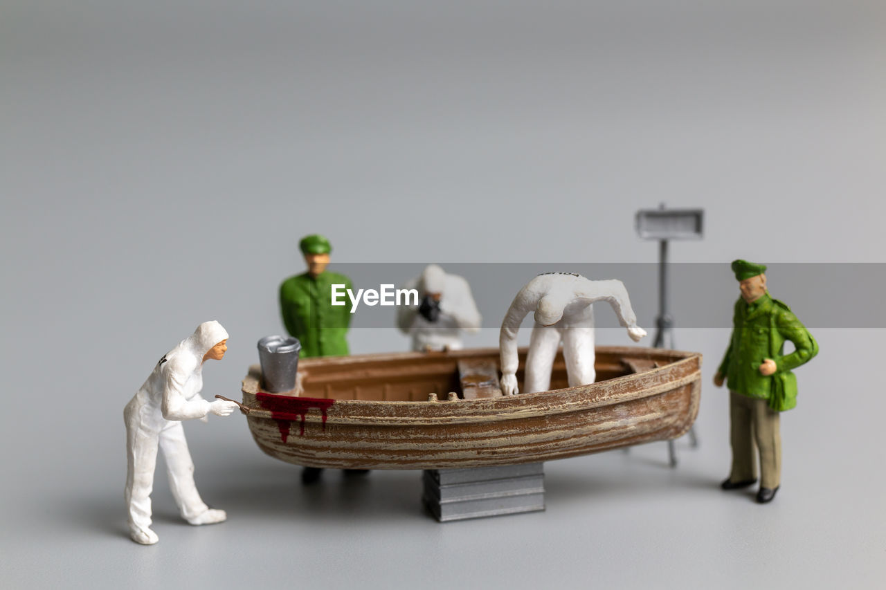 Miniature people police and detective are working on the boat , crime scene investigation concept