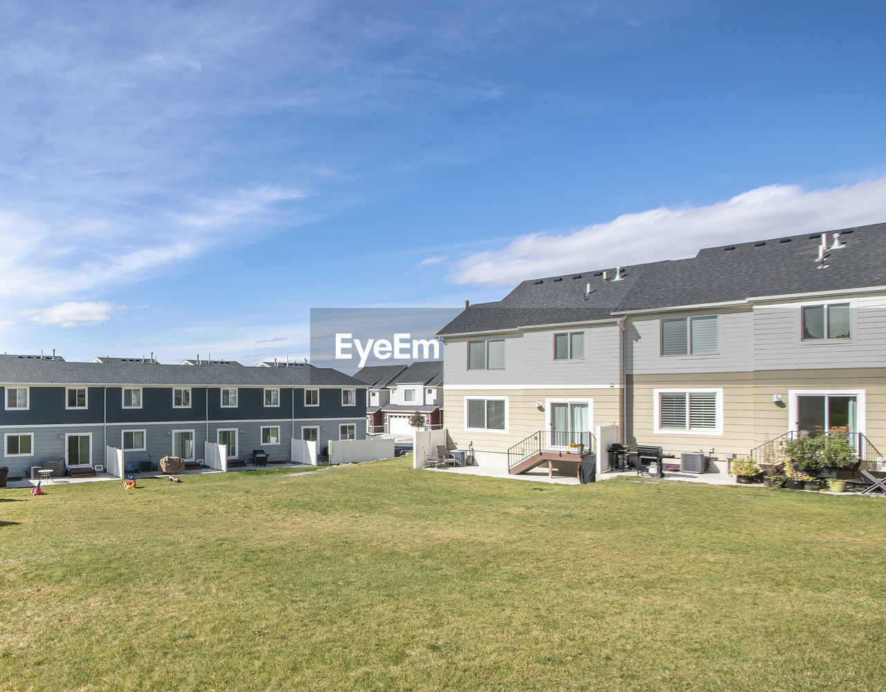 HOUSES ON FIELD AGAINST SKY