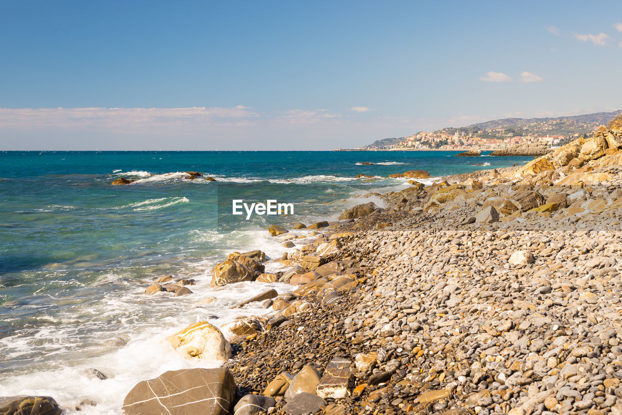 Scenic view of rocky shore against sky