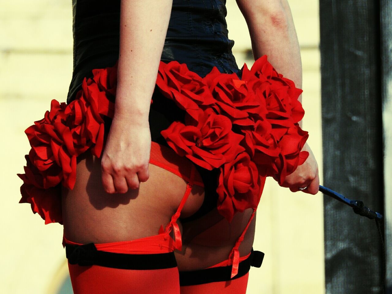 LOW SECTION OF MAN AND WOMAN STANDING ON RED FLOWERS