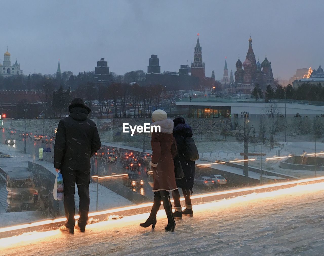 REAR VIEW OF PEOPLE STANDING ON STREET DURING WINTER