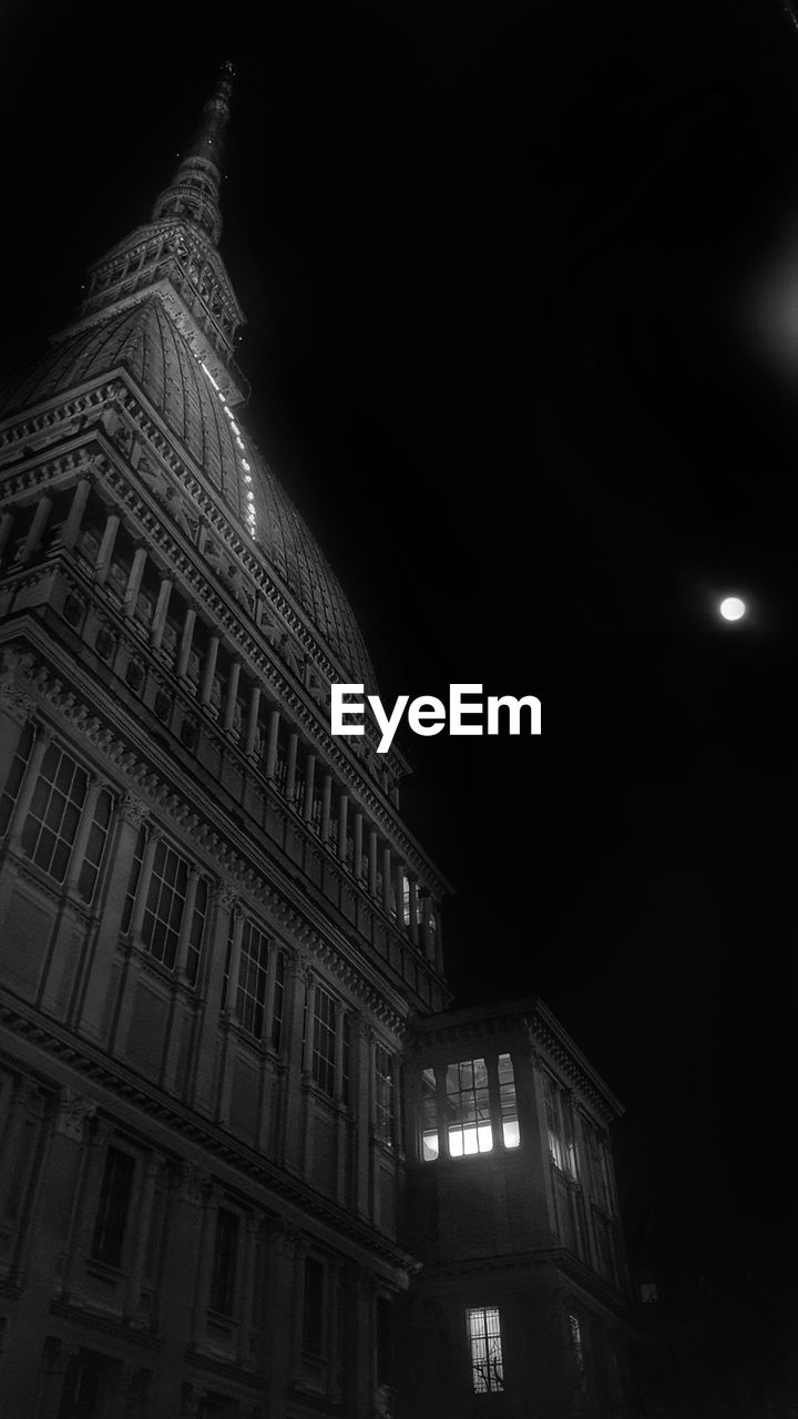 LOW ANGLE VIEW OF ILLUMINATED BUILDING AGAINST SKY