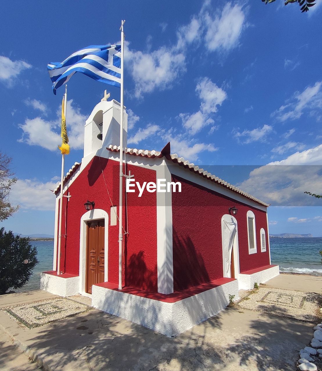 Traditional red church by the beach in greek island