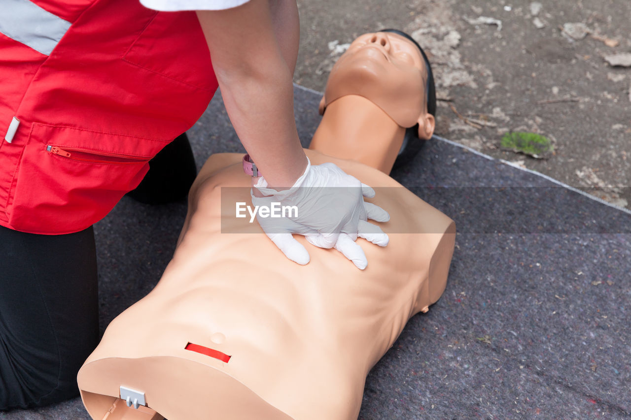 Low section of person performing cpr on dummy