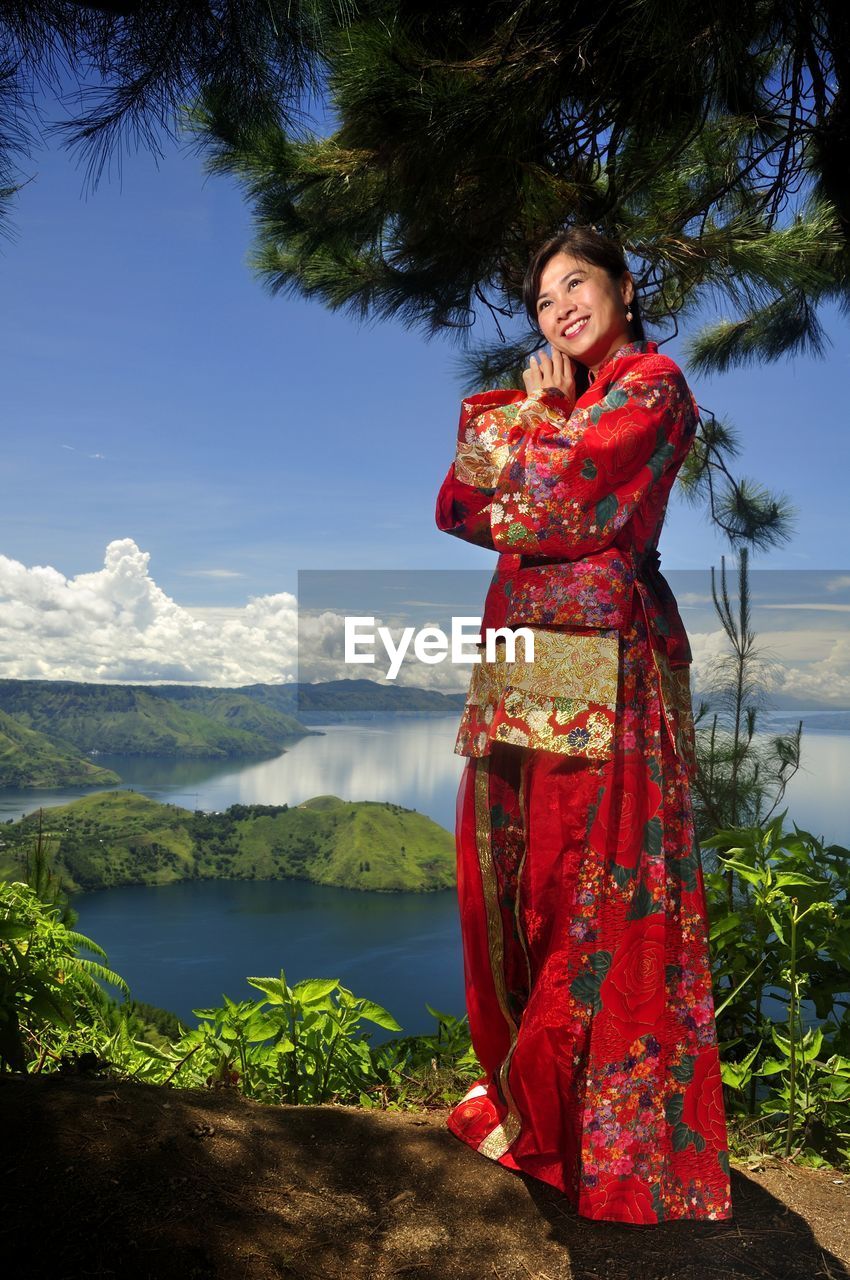 Woman in traditional clothing standing on lakeshore