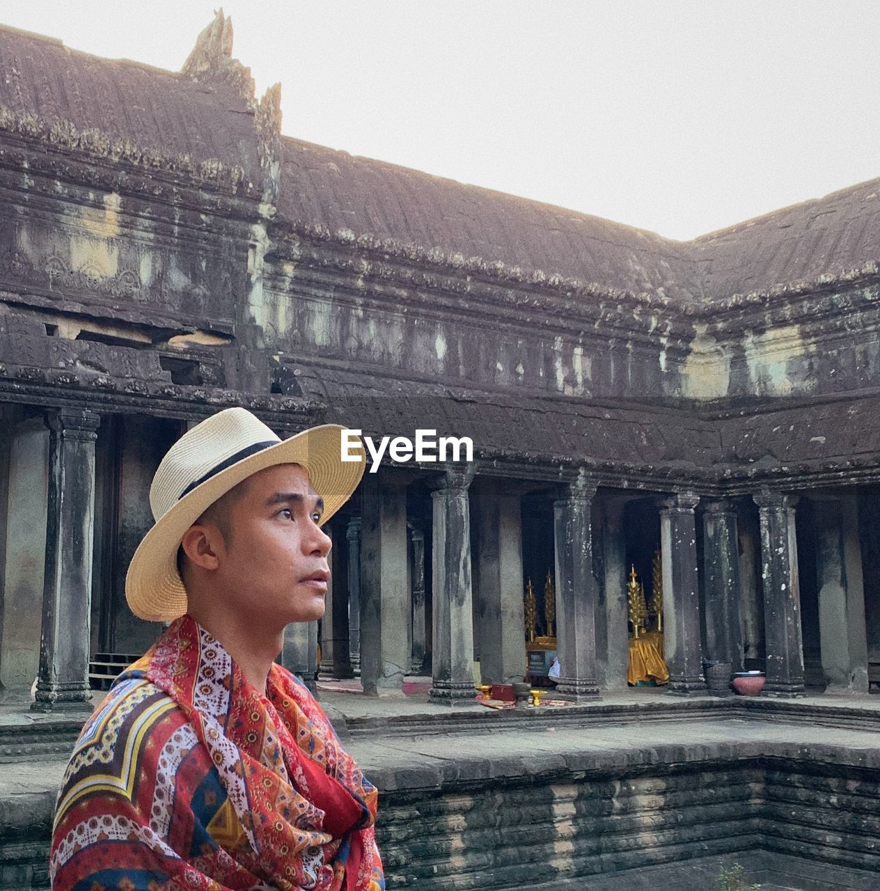 Mid adult man standing by historic temple against clear sky