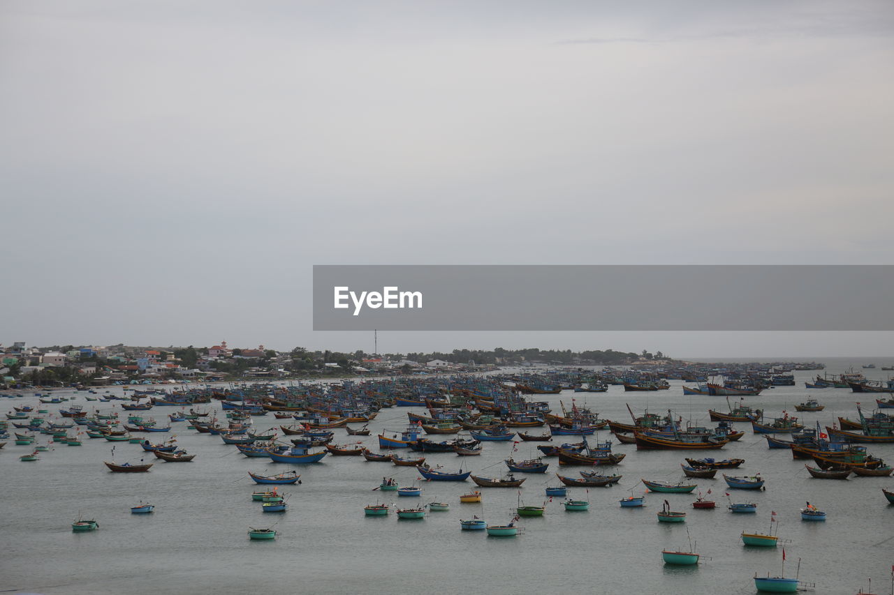 HIGH ANGLE VIEW OF TOWNSCAPE AGAINST SEA