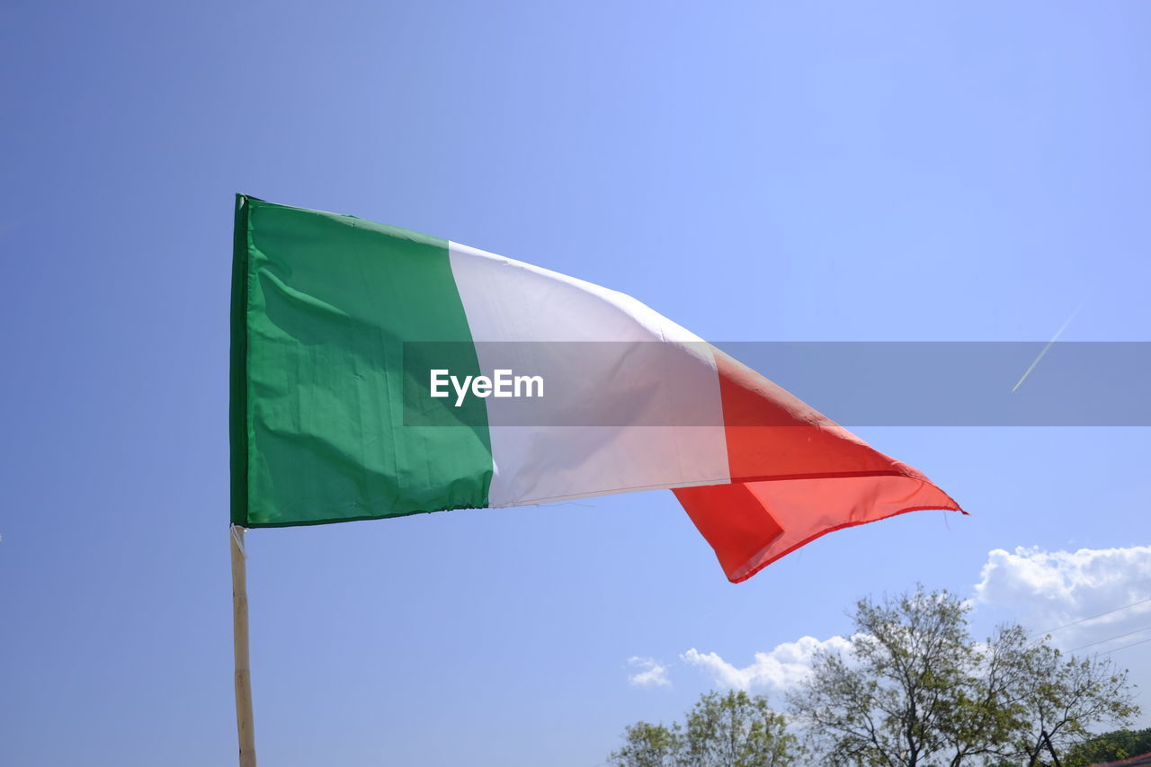 Low angle view of italian flag waving against sky