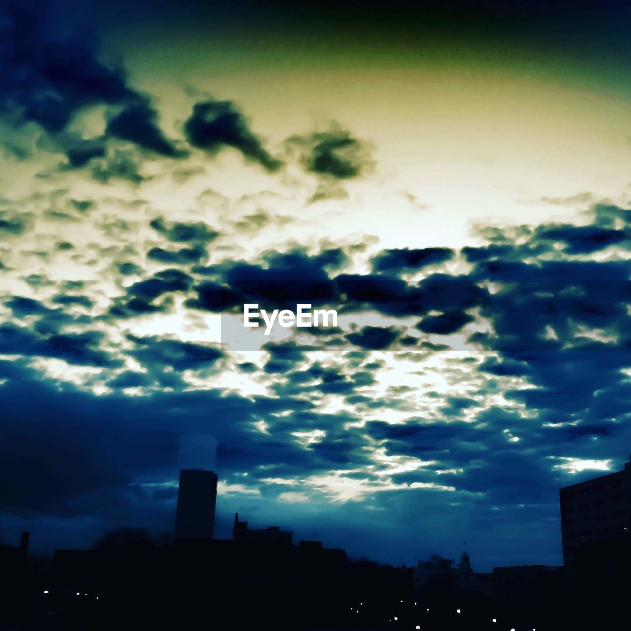 LOW ANGLE VIEW OF BUILDINGS AGAINST CLOUDY SKY