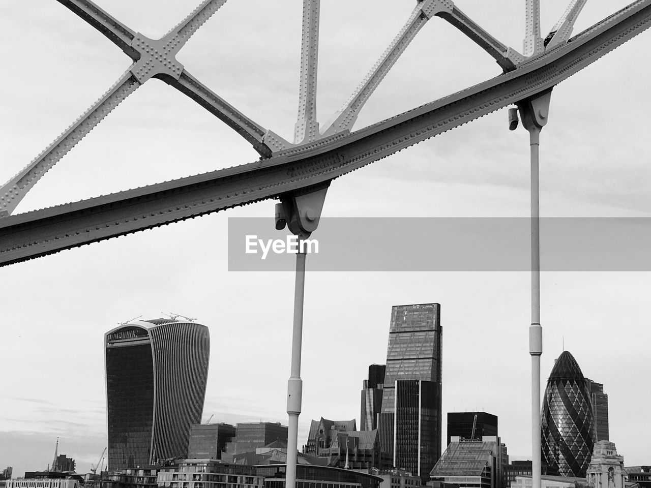 Architectural detail of tower bridge by cityscape against sky