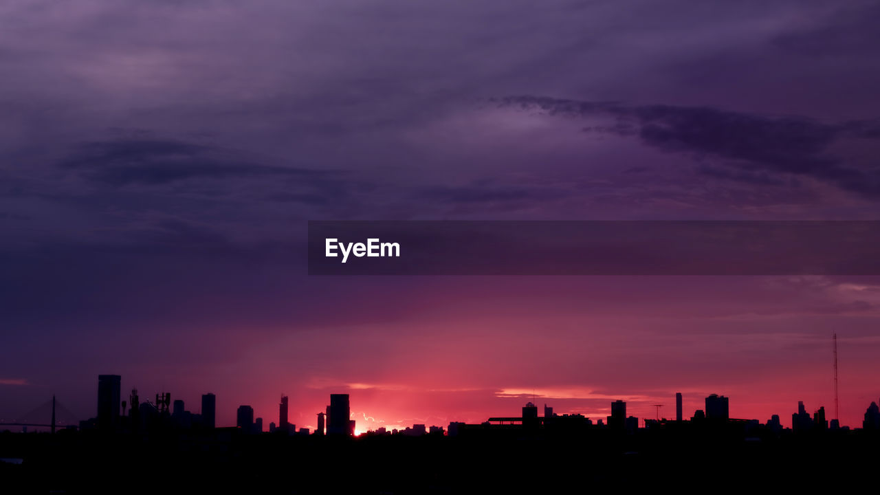 Silhouette buildings against sky during sunset