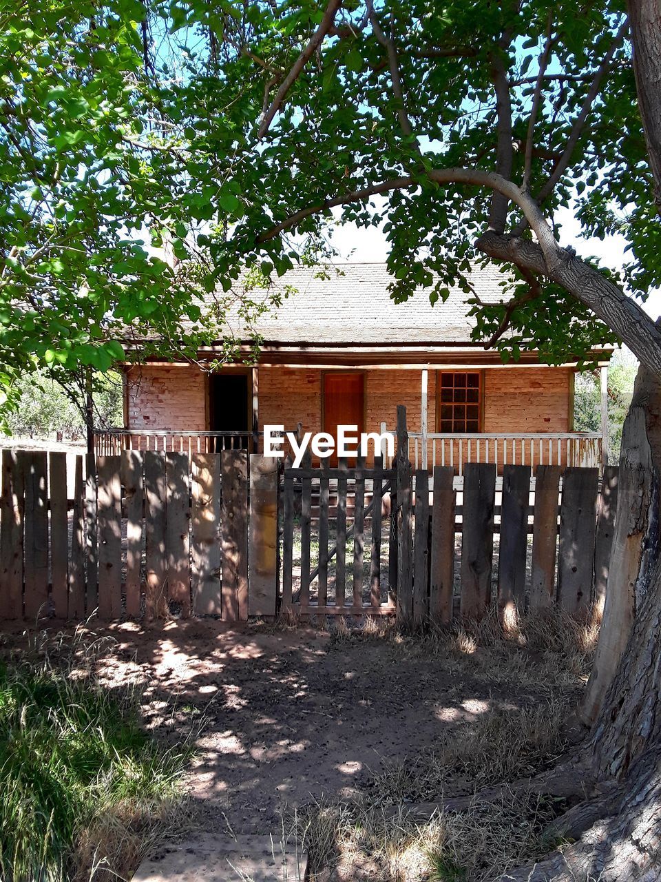 EXTERIOR OF HOUSE ON FIELD BY TREES