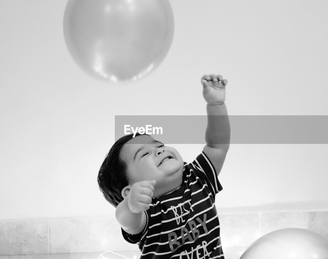 Cute boy playing with balloon at home