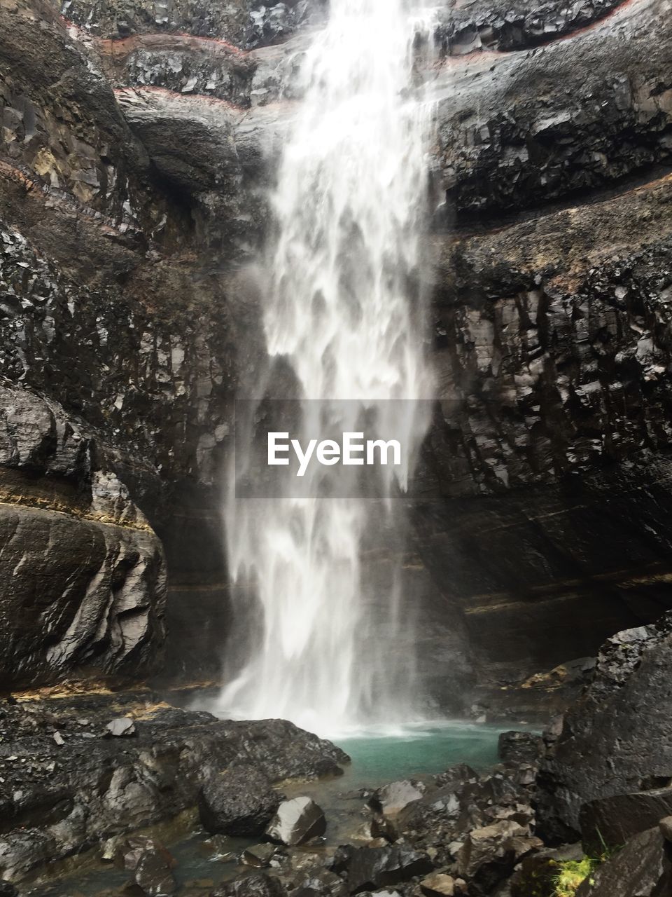 WATERFALL WITH ROCKS IN BACKGROUND