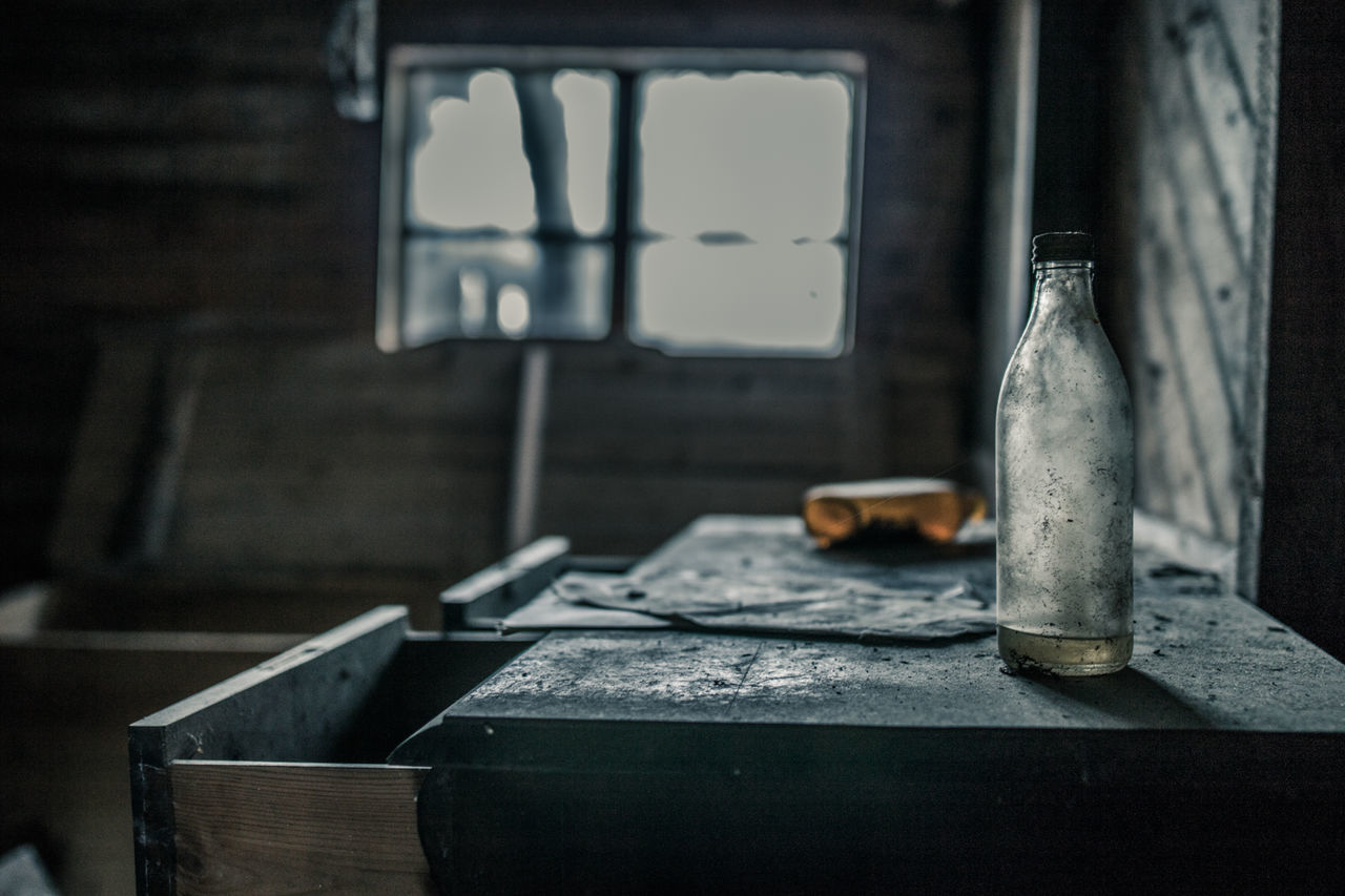 Old bottle on table in abandoned house