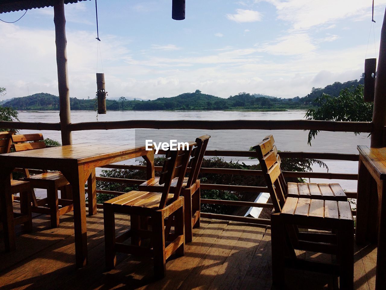 EMPTY CHAIRS AND TABLE AGAINST SKY