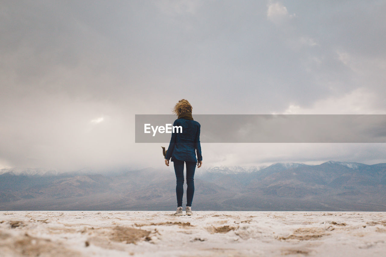 Rear view of woman standing against sky