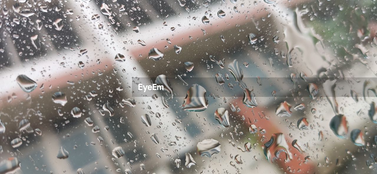 Full frame shot of wet glass window during rainy season