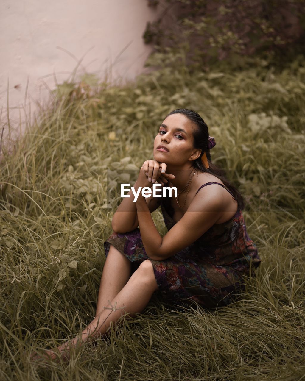 Portrait of young woman sitting on field