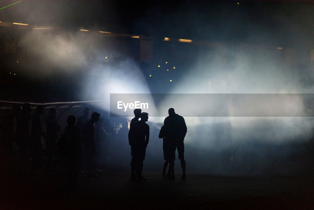 Silhouette people in illuminated stadium