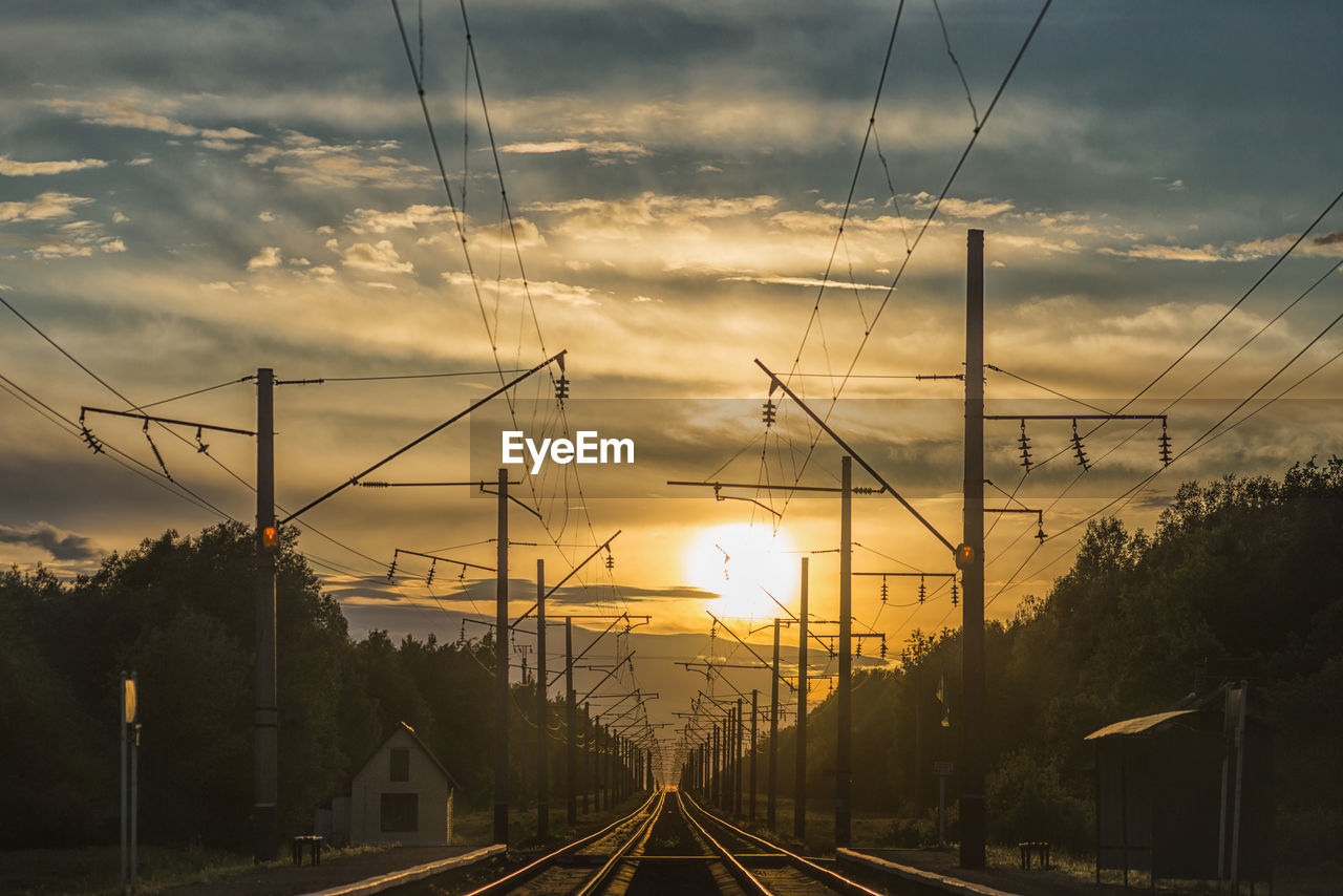 Railroad tracks against sky during sunset