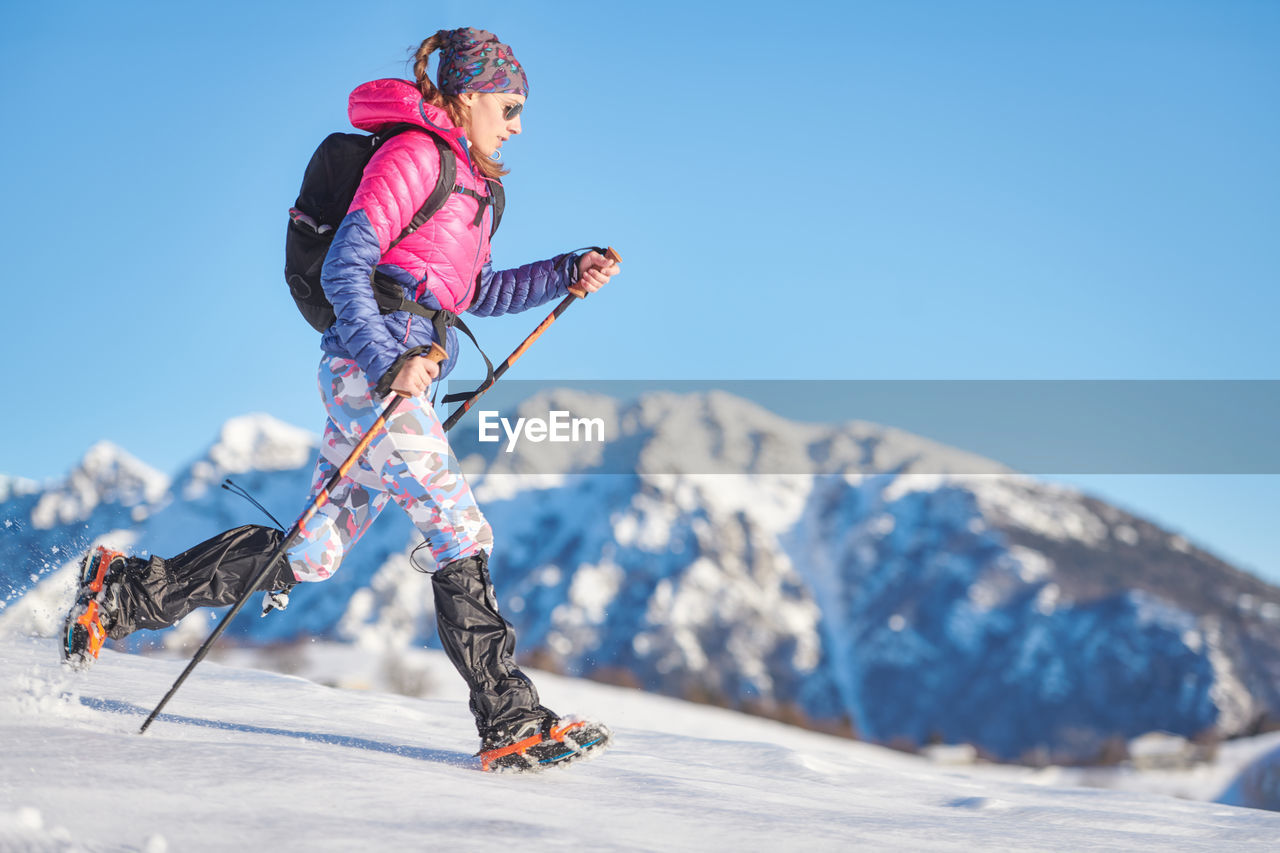 Young sporty woman in the snow with crampons and gaiters