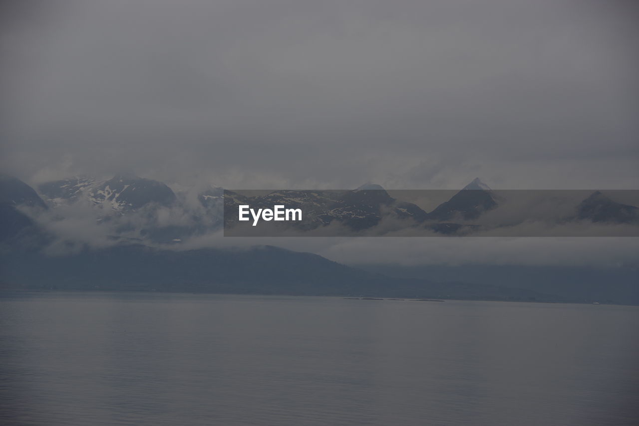 SCENIC VIEW OF SEA BY MOUNTAIN AGAINST SKY