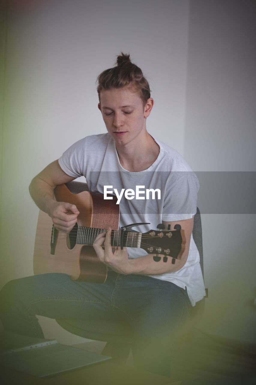 Focused young singer while singing and playing guitar in an afternoon idyll. a common portrait 