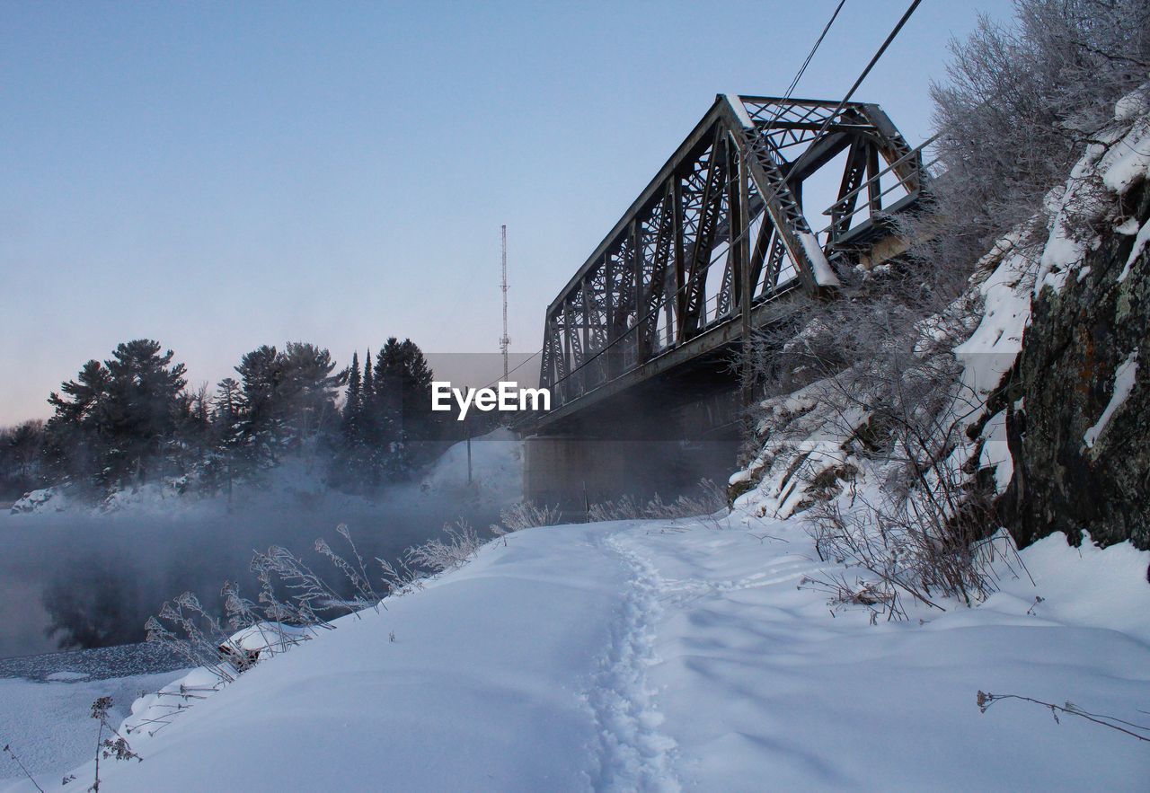 LOW ANGLE VIEW OF BRIDGE IN WINTER