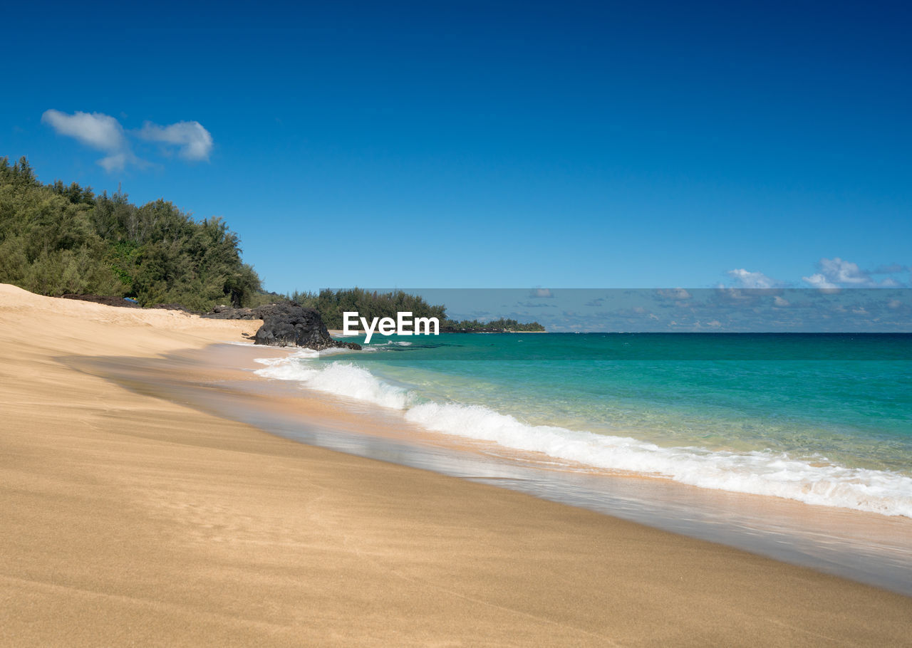 VIEW OF BEACH AGAINST BLUE SKY