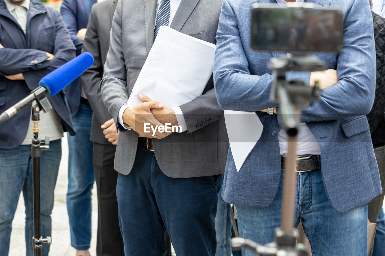 Whistleblower holding documents, giving statement at news conference or media event