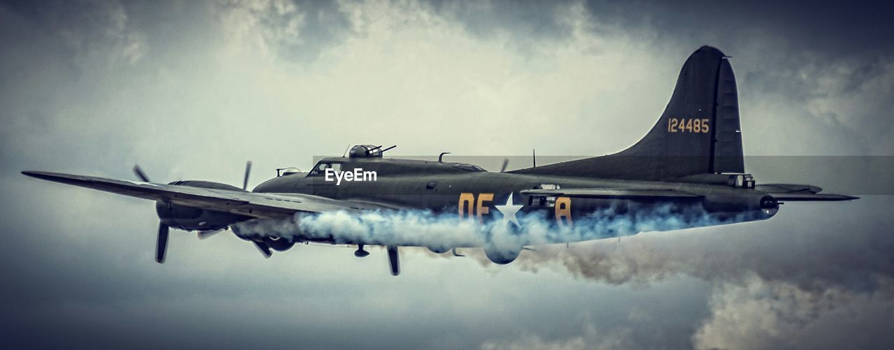 AIRPLANE FLYING OVER CLOUDY SKY