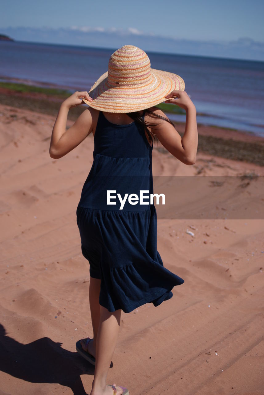 Rear view of woman wearing straw hat at beach