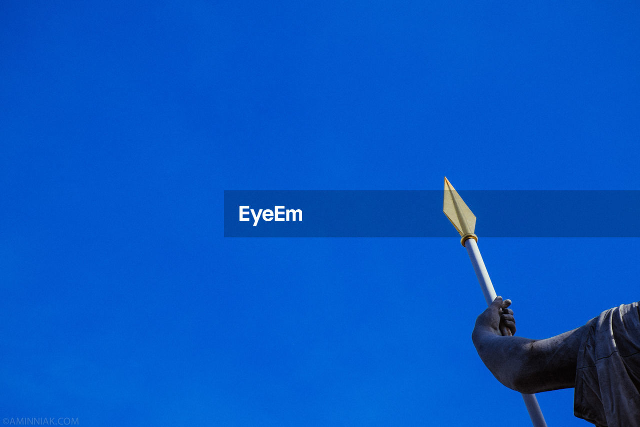 Cropped image of statue against clear blue sky