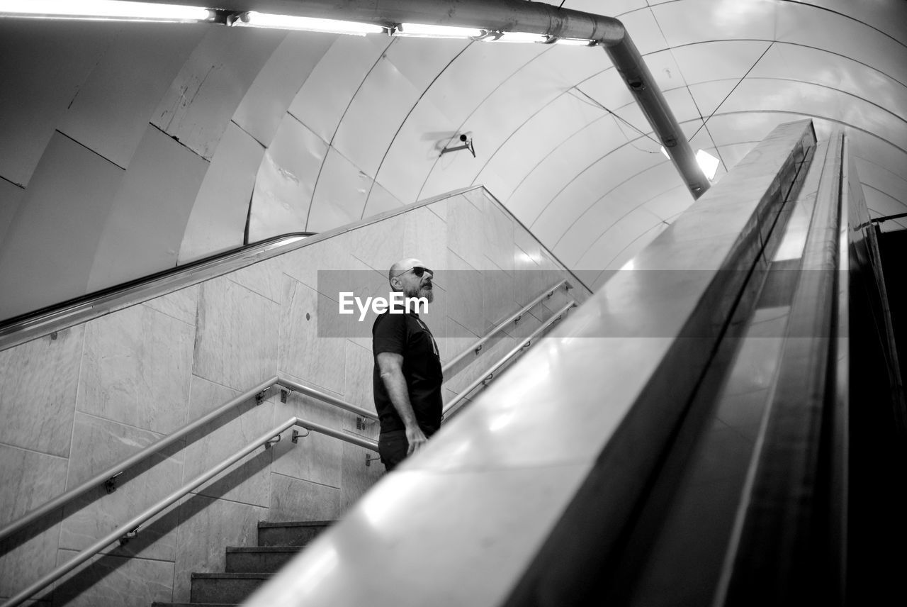 Man standing on steps at subway station